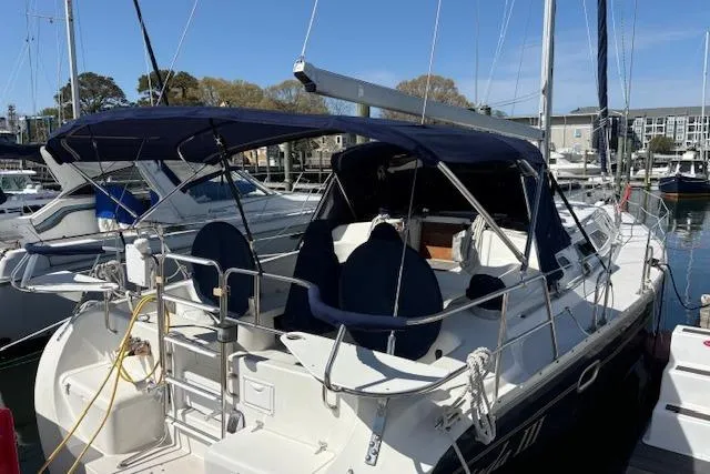 Slide: The Image of 2002 Catalina 400 MkII sailboat docked in a marina, featuring a spacious cockpit. - 31