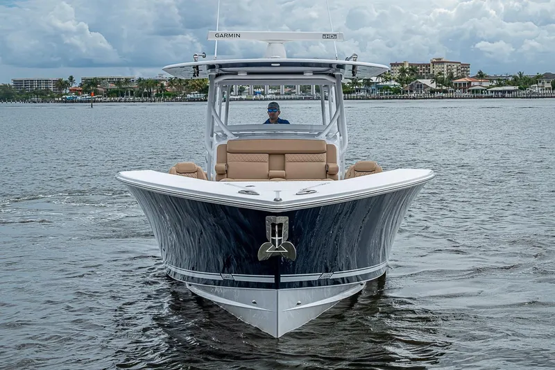 Slide: The Image of 2024 Jupiter 43 boat cruising on water with cityscape background. - 13