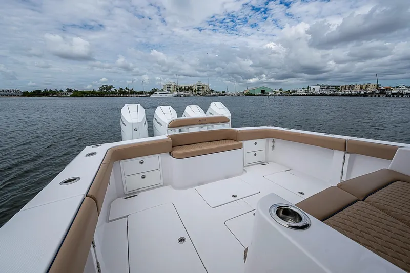 Slide: The Image of 2024 Jupiter 43 boat with spacious deck and multiple outboard engines on a calm waterway. - 28