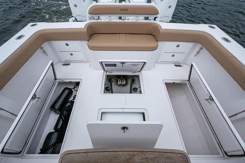Slide: The Image of 2024 Jupiter 43 boat interior with storage compartments and cushioned seating. - 29