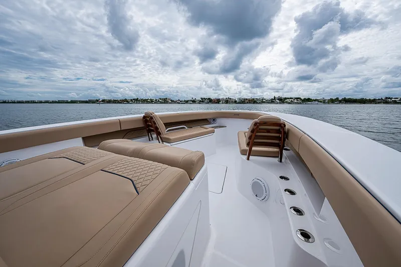 Slide: The Image of 2024 Jupiter 43 boat deck with luxurious seating and ocean view under cloudy sky. - 34