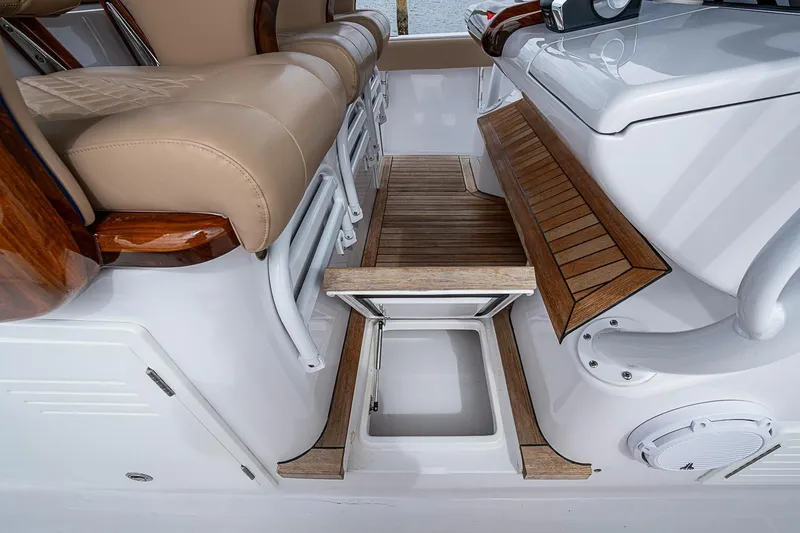 Slide: The Image of Luxurious seating and storage area on 2024 Jupiter 43 boat, featuring wood accents and beige upholstery. - 50