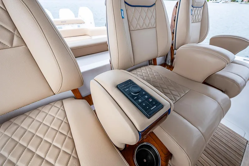 Slide: The Image of Luxurious seating on 2024 Jupiter 43 boat with diamond-stitched upholstery and control panel. - 55