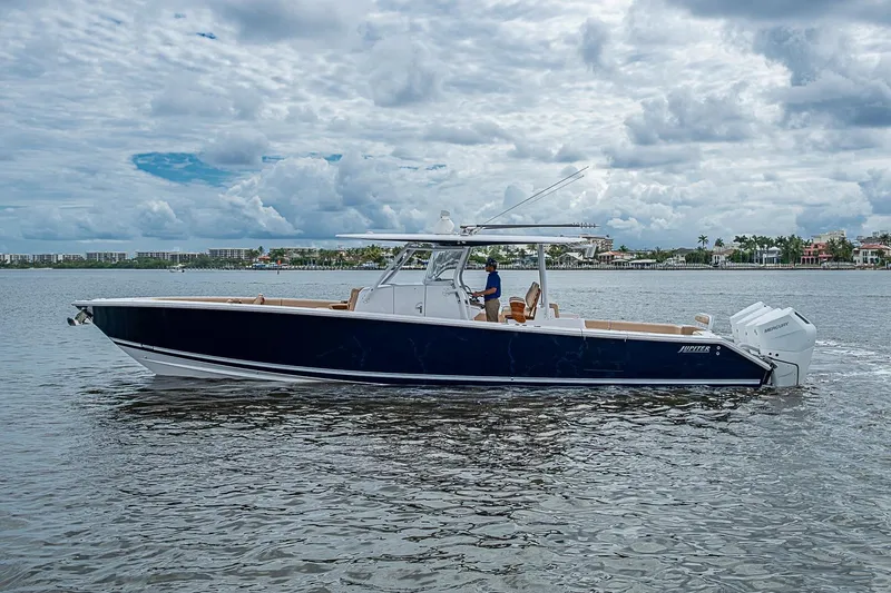 Slide: The Image of 2024 Jupiter 43 boat cruising on a calm waterway under a cloudy sky. - 6