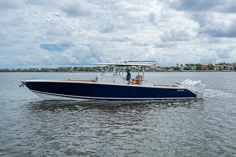 Slide: The Image of 2024 Jupiter 43 boat cruising on a calm waterway under a cloudy sky. - 7
