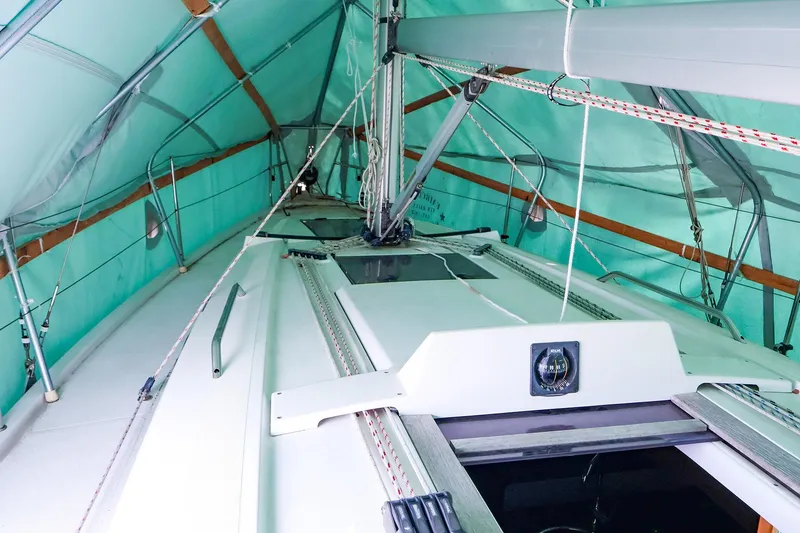 Slide: The Image of 2019 Hanse 315 sailboat under protective cover, showcasing deck and rigging details. - 23