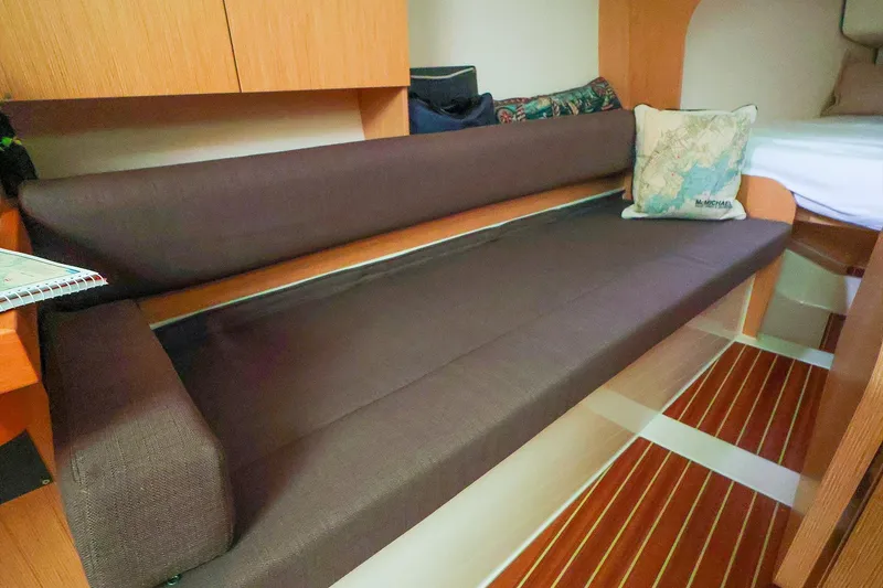 Slide: The Image of Interior of 2019 Hanse 315 yacht with brown seating and nautical-themed pillow. - 5