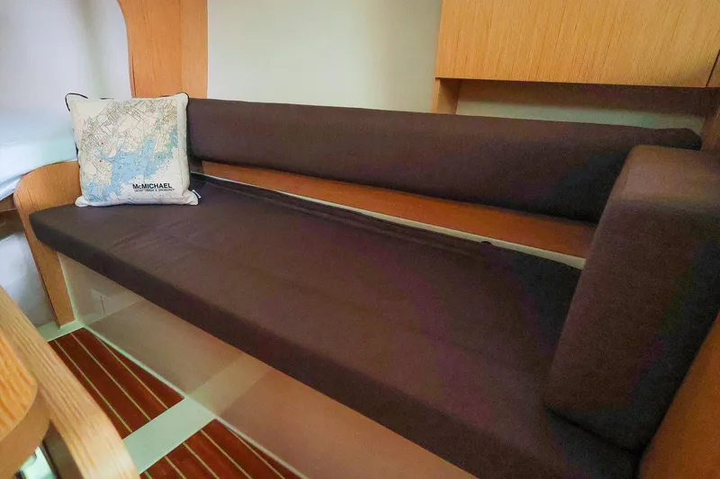 Slide: The Image of 2019 Hanse 315 interior with brown seating and nautical map pillow. - 6
