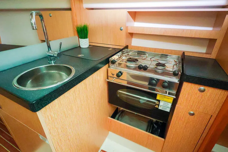 Slide: The Image of Compact kitchen in 2019 Hanse 315 yacht with sink, stove, and wooden cabinetry. - 8