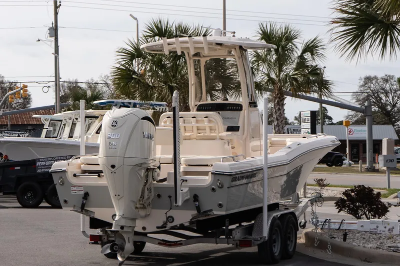 Slide: The Image of 2024 Grady-White 251 Coastal Explorer boat on trailer, parked near palm trees. - 14