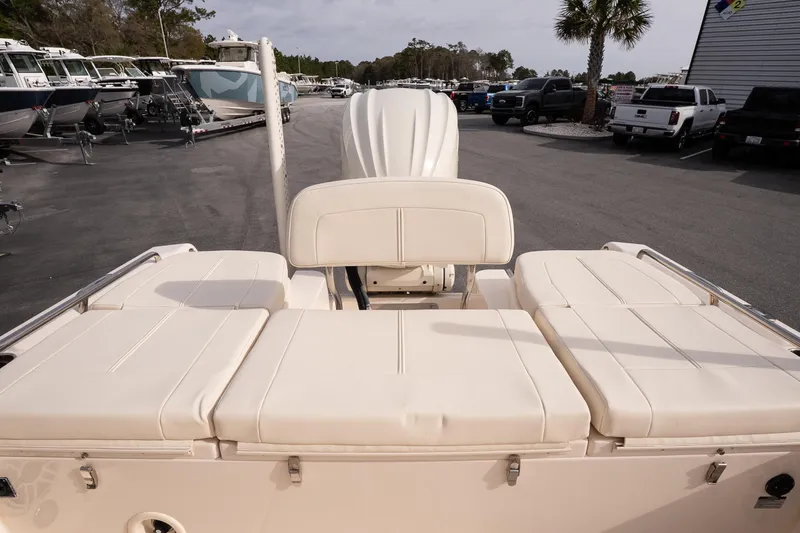 Slide: The Image of 2024 Grady-White 251 Coastal Explorer boat with cushioned seating, parked in a marina. - 16