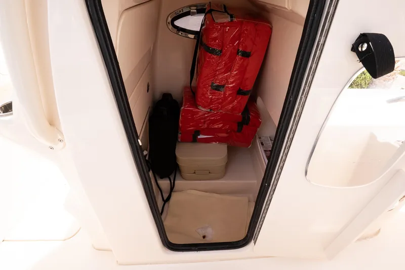 Slide: The Image of Storage compartment in 2024 Grady-White 251 Coastal Explorer with life jackets and cooler. - 24