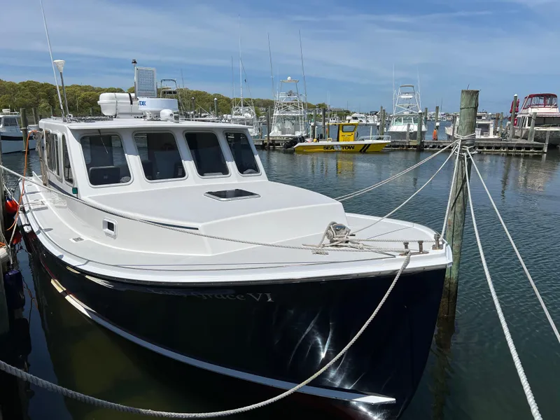 Slide: The Image of 2022 Wesmac 38 boat docked in a marina under a clear blue sky. - 10