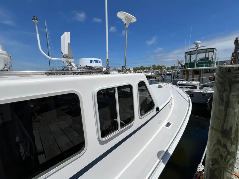 Slide: The Image of 2022 Wesmac 38 boat docked at marina under clear blue sky. - 12