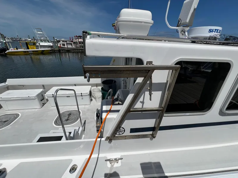 Slide: The Image of 2022 Wesmac 38 boat docked, featuring a clean deck and fishing equipment. - 13
