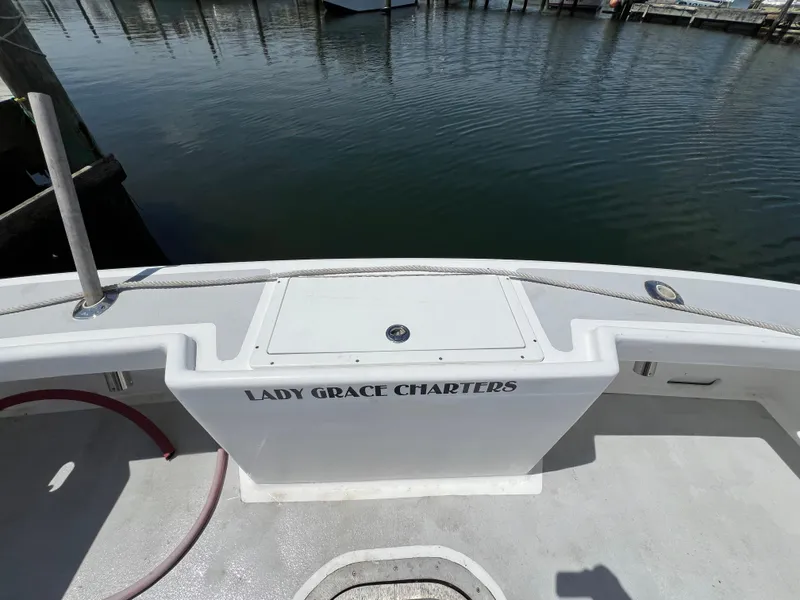 Slide: The Image of Wesmac 38 boat, 2022 model, docked with "Lady Grace Charters" signage on deck. - 14