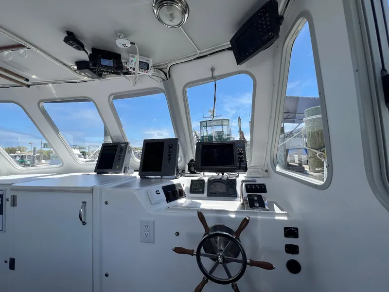 Slide: The Image of Interior view of 2022 Wesmac 38 boat cockpit with navigation equipment and steering wheel. - 18