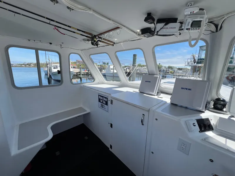 Slide: The Image of Interior of a 2022 Wesmac 38 boat, featuring navigation equipment and waterfront views. - 19