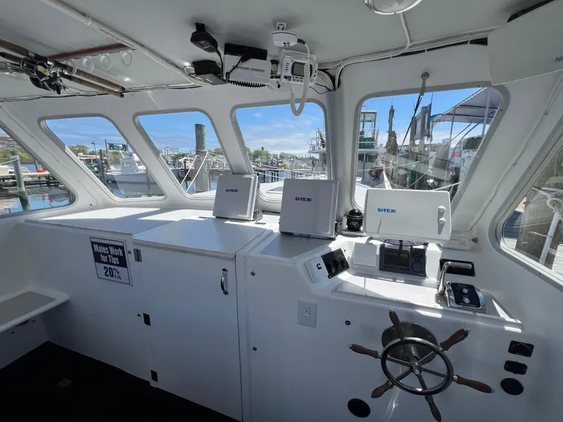 Slide: The Image of Interior of 2022 Wesmac 38 boat with navigation equipment and steering wheel. - 21