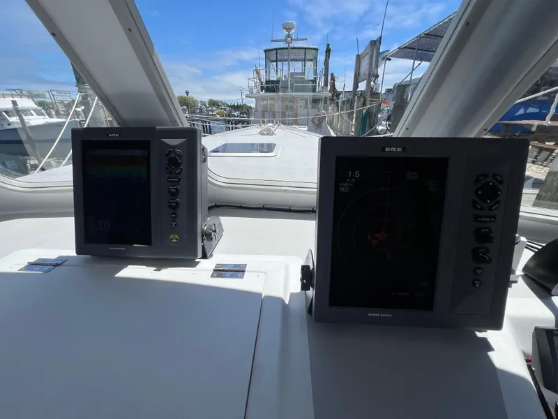 Slide: The Image of Helm of 2022 Wesmac 38 boat with navigation screens and marina view. - 24