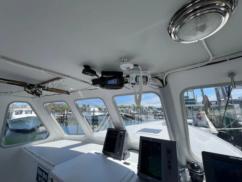 Slide: The Image of Interior view of 2022 Wesmac 38 boat with navigation equipment and marina background. - 26