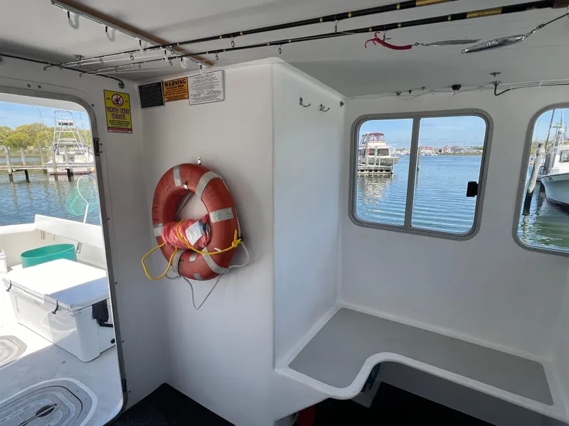 Slide: The Image of Interior of 2022 Wesmac 38 boat with life preserver and dock view. - 32