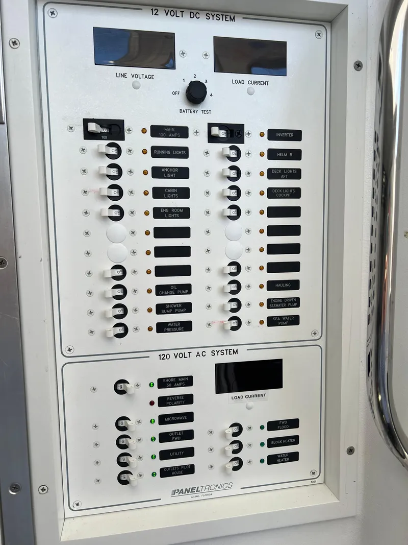 Slide: The Image of Electrical control panel on a 2022 Wesmac 38 boat, featuring 12V DC and 120V AC systems. - 38