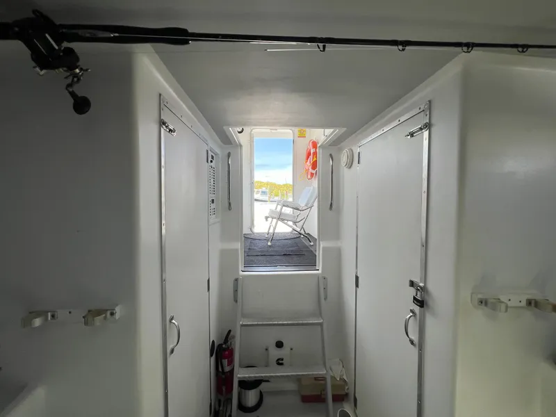 Slide: The Image of Interior view of 2022 Wesmac 38 boat, featuring white cabin and outdoor seating. - 40