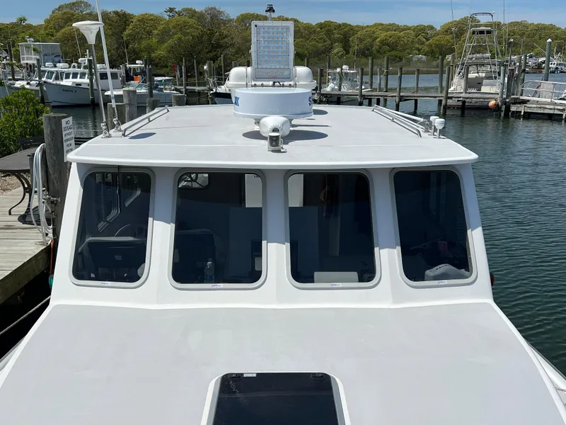 Slide: The Image of 2022 Wesmac 38 boat docked at a marina, showcasing its cabin and deck. - 9