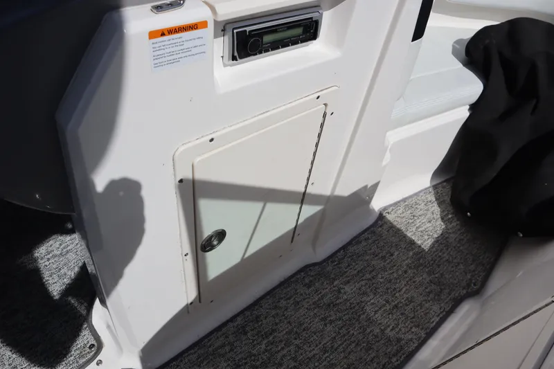 Slide: The Image of Interior view of a 2017 Chaparral 21 H2O Sport boat, featuring a storage compartment and stereo system. - 11