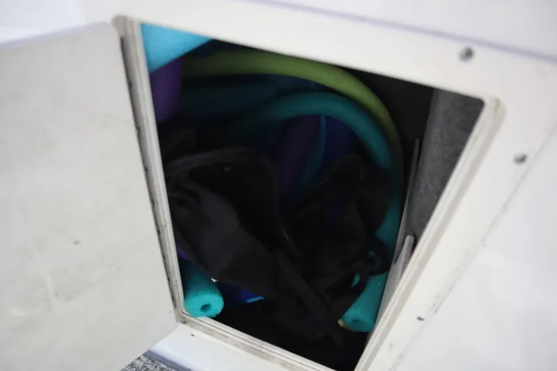 Slide: The Image of Storage compartment in 2017 Chaparral 21 H2O Sport boat with pool noodles. - 14