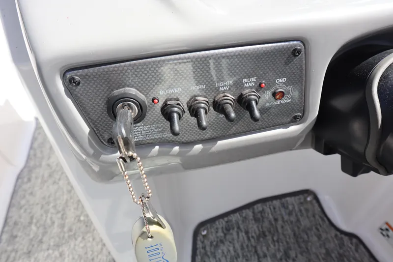 Slide: The Image of Control panel of a 2017 Chaparral 21 H2O Sport boat with key and switches. - 17