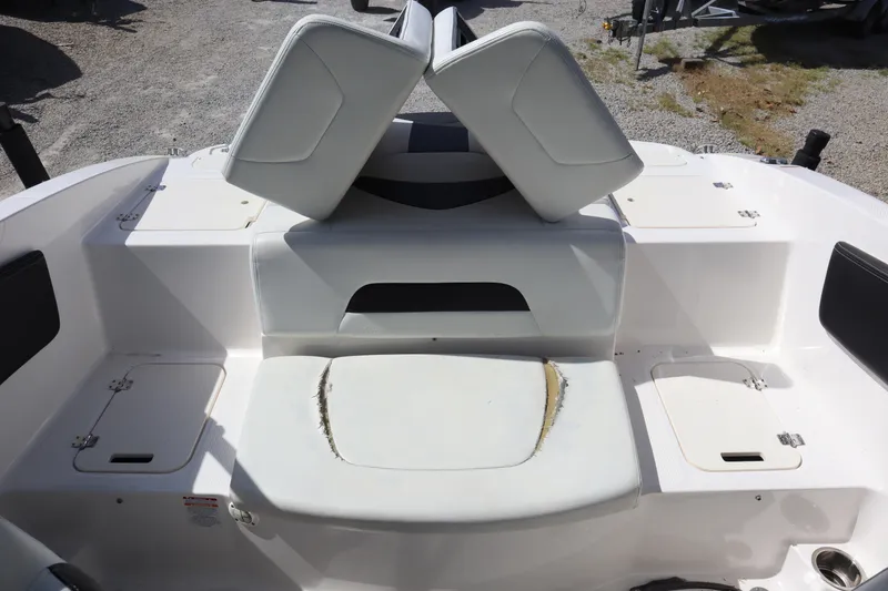 Slide: The Image of 2017 Chaparral 21 H2O Sport boat interior with white seating and storage compartments. - 25