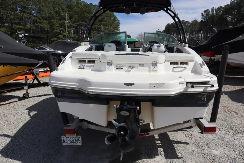 Slide: The Image of 2017 Chaparral 21 H2O Sport boat, rear view, parked on gravel with trees in background. - 3