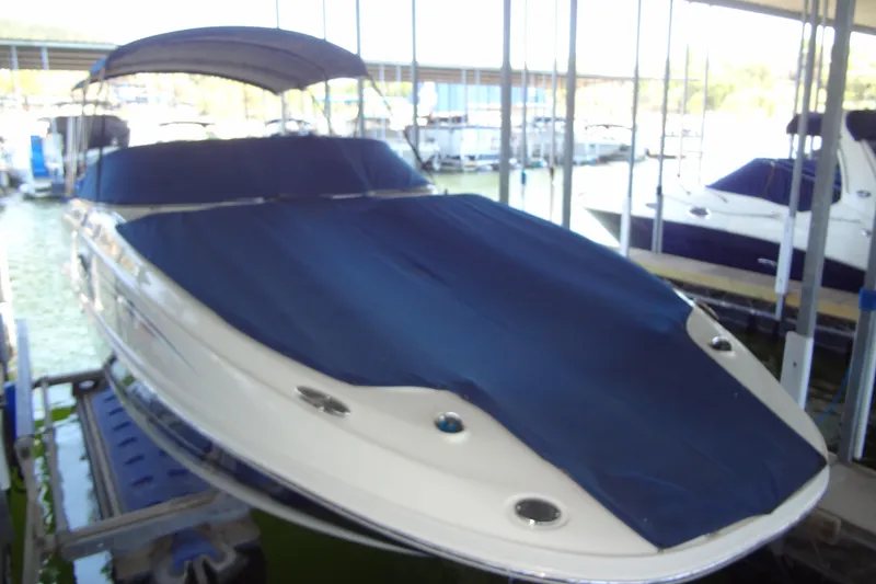 Slide: The Image of 2010 Sea Ray 260 Sundeck boat with blue cover in marina. - 10