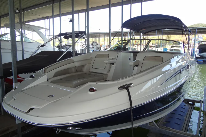 Slide: The Image of 2010 Sea Ray 260 Sundeck boat docked in a marina, featuring spacious seating. - 15