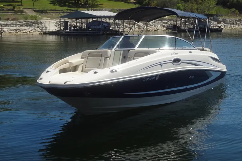 Slide: The Image of 2010 Sea Ray 260 Sundeck boat on calm water, featuring sleek design and spacious seating. - 2