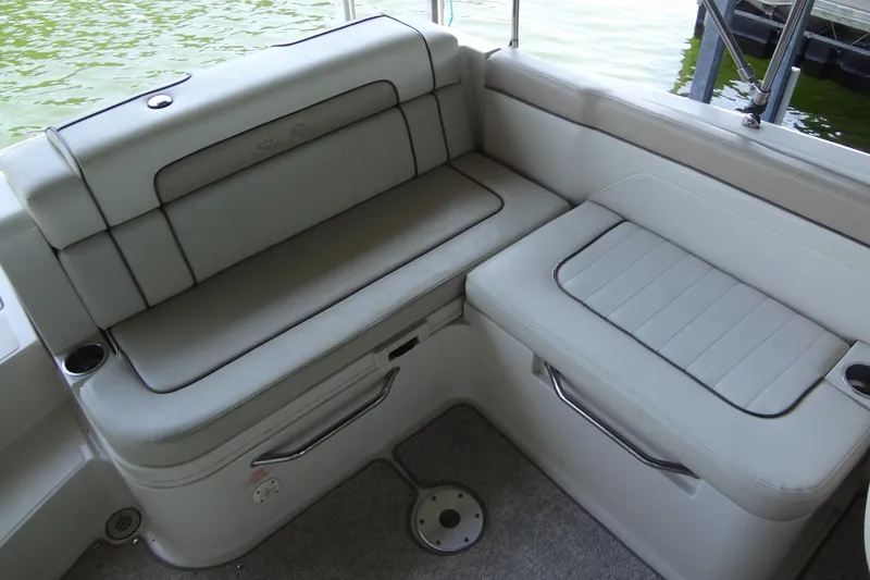 Slide: The Image of 2010 Sea Ray 260 Sundeck interior seating with light gray upholstery and cup holders. - 23