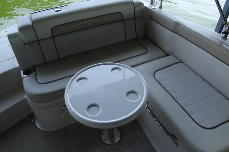 Slide: The Image of 2010 Sea Ray 260 Sundeck interior with gray seating and round table. - 24