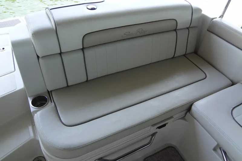 Slide: The Image of 2010 Sea Ray 260 Sundeck boat seating with cup holder, featuring white upholstery. - 26