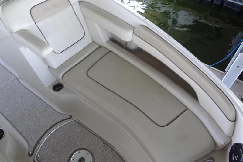 Slide: The Image of 2010 Sea Ray 260 Sundeck interior seating with beige upholstery and cup holders. - 34