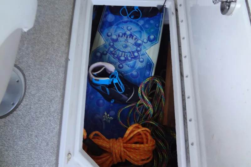 Slide: The Image of Storage compartment in 2010 Sea Ray 260 Sundeck with wakeboard and ropes. - 49