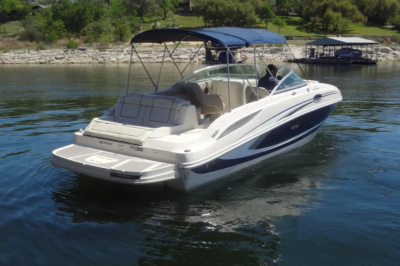 Slide: The Image of 2010 Sea Ray 260 Sundeck boat on calm water with canopy and seating. - 8