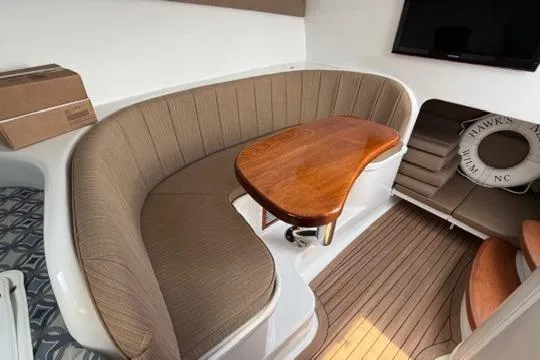 Slide: The Image of 2012 Shearline Express Fisherman interior with curved seating, wooden table, and nautical decor. - 21