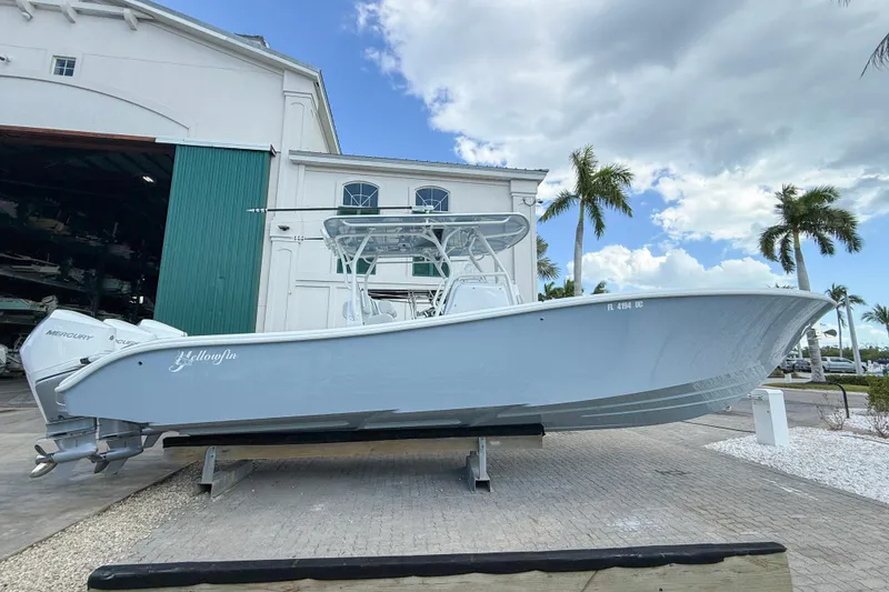 The Image of 2024 Yellowfin 34 Offshore boat displayed outdoors near a marina with palm trees. - 0
