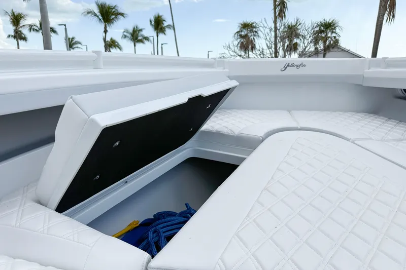 Slide: The Image of 2024 Yellowfin 34 Offshore boat with open storage compartment and white quilted seating. - 15