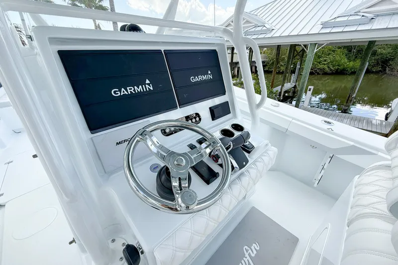 Slide: The Image of 2024 Yellowfin 34 Offshore boat helm with Garmin displays and steering wheel. - 4