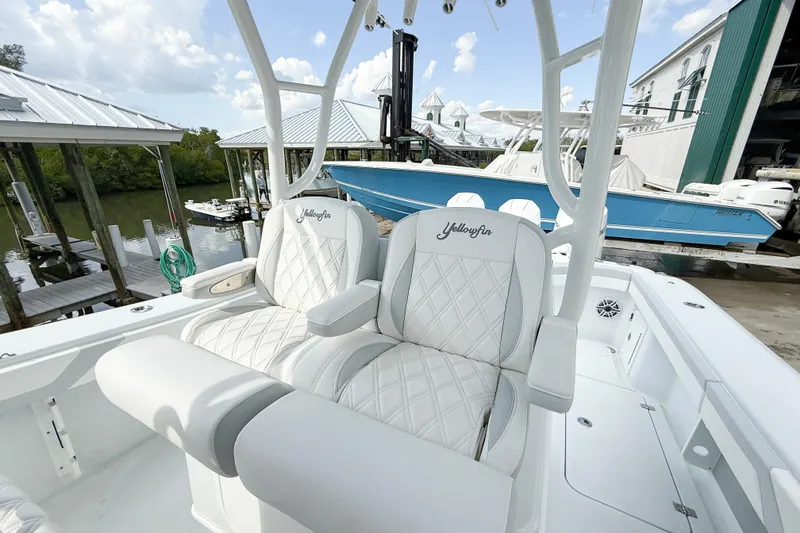 Slide: The Image of 2024 Yellowfin 34 Offshore boat with luxurious white seating at a marina. - 5