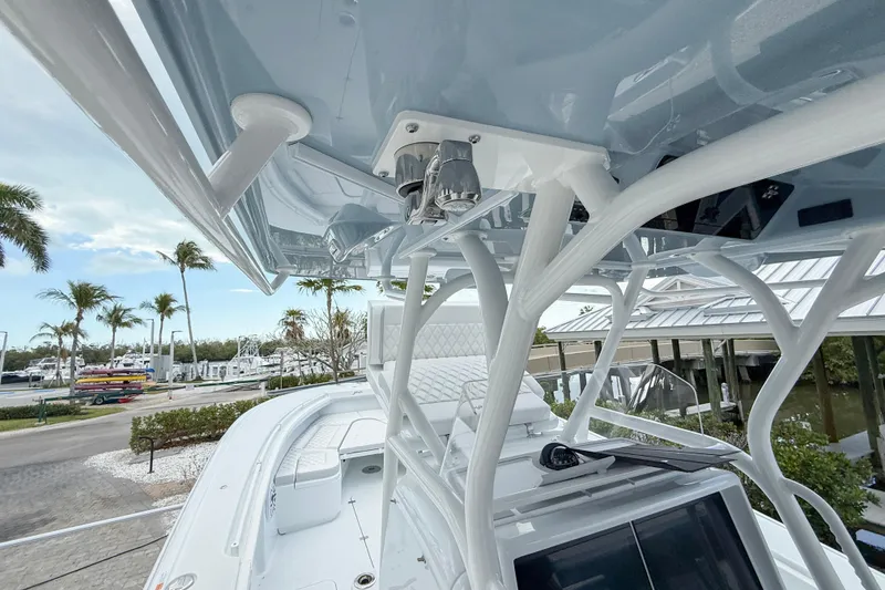 Slide: The Image of 2024 Yellowfin 34 Offshore boat with sleek design and advanced features, docked near palm trees. - 17