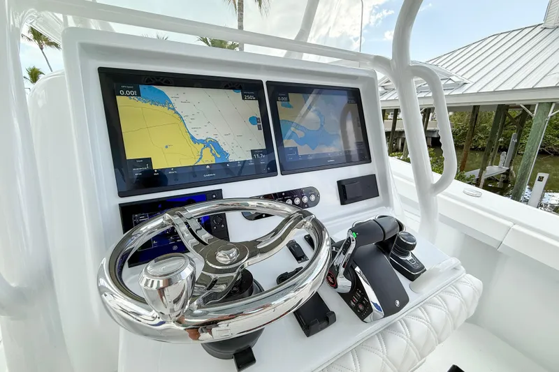 Slide: The Image of 2024 Yellowfin 34 Offshore boat dashboard with dual navigation screens and steering wheel. - 19